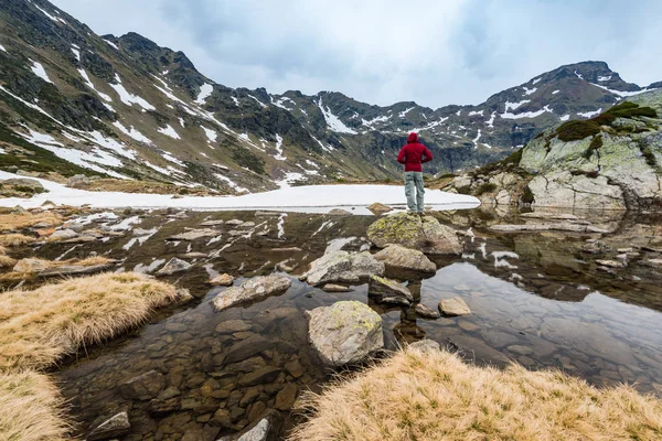 Caminante se para en roca cerca del lago en Andorra — Foto de Stock