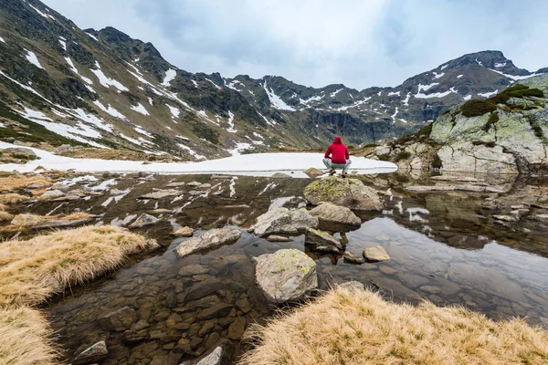 Senderista se sienta en la roca cerca del lago en Andorra — Foto de Stock