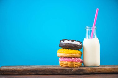 Süt şişesi ve yığın Donuts ahşap tahta üzerinde