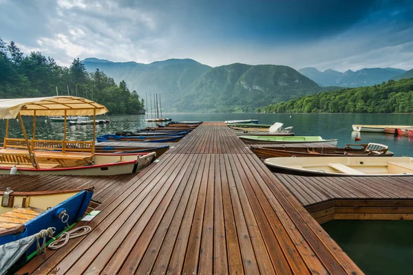 スロブ ボーヒニ湖で雨の日でカラフルなボートで木製の桟橋 — ストック写真