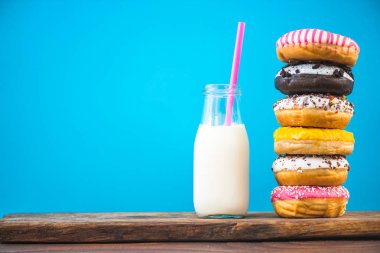 Süt şişesi ve yığın Donuts ahşap tahta üzerinde