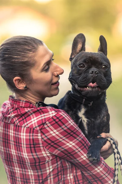 Joven hopster mujer sosteniendo francés Bulldog cachorro —  Fotos de Stock