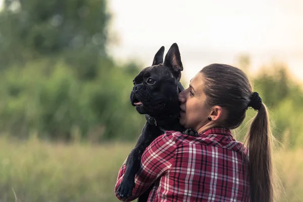 Atractiva mujer besando francés Bulldog cachorro —  Fotos de Stock