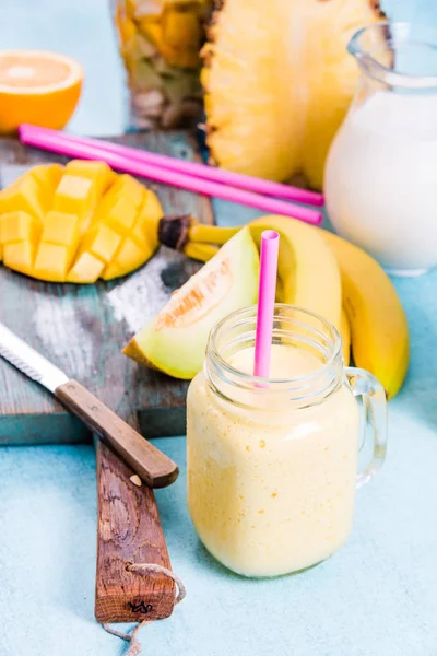 Mason jar with tropical vibrant smoothie and ingredients — Stock Photo, Image