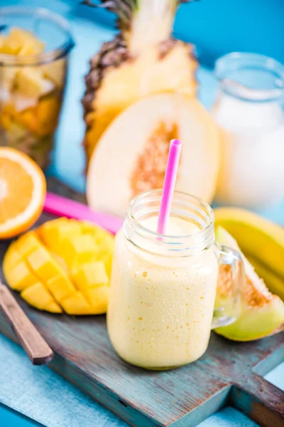 Mason jar with tropical vibrant smoothie and ingredients — Stock Photo, Image