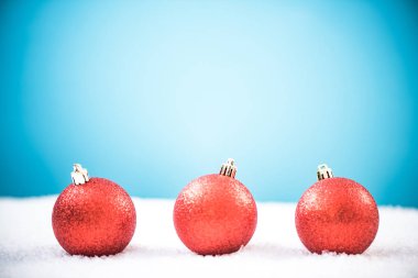 Kırmızı Noel topları karda, kopya alanı