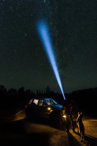 Homem e cão observando estrelas no deserto com tocha — Fotografia de Stock