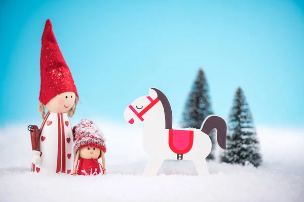 Happy family and rocking horse on snow — Stock Photo, Image