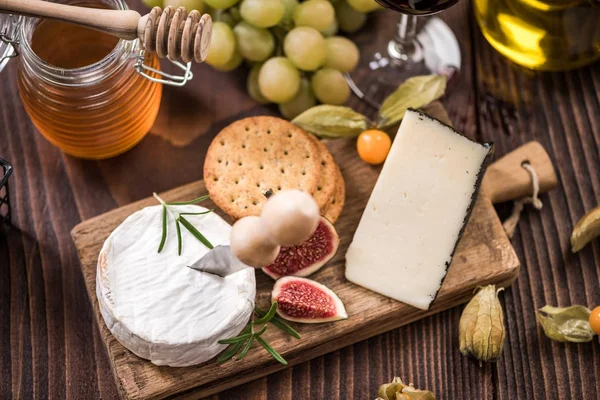 Tábua de queijo com biscoitos, figo e uvas — Fotografia de Stock