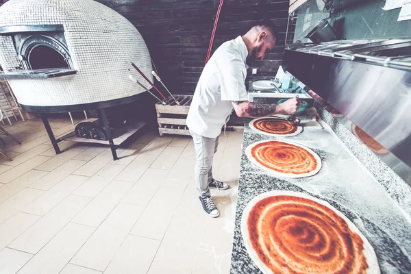 Bärtiger tätowierter Pizzaiolo-Chef in lokaler Pizzeria — Stockfoto