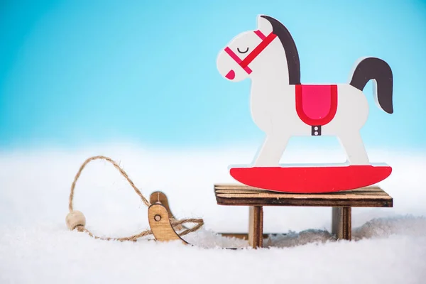 Wooden rocking horse on snow sledge