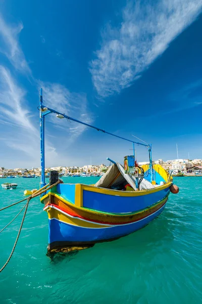 Beautiful painted fishing boat on turquoise water in Marsaxlokk,