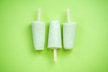 Pastel yeşil zemin üzerine yeşil popsicles