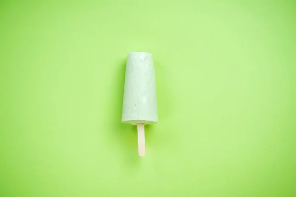 Зеленое мороженое на зеленом пастельном фоне — стоковое фото