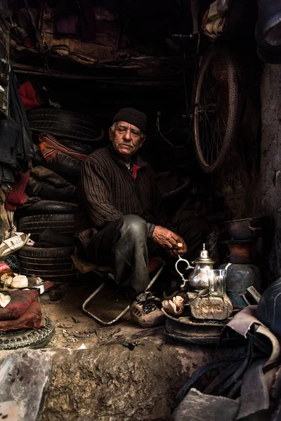 Człowiek w slumsach warsztat havinf herbaty na obiad. — Zdjęcie stockowe