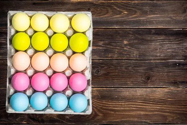 Ahşap arka plan üzerinde canlı Paskalya yumurtaları — Stok fotoğraf