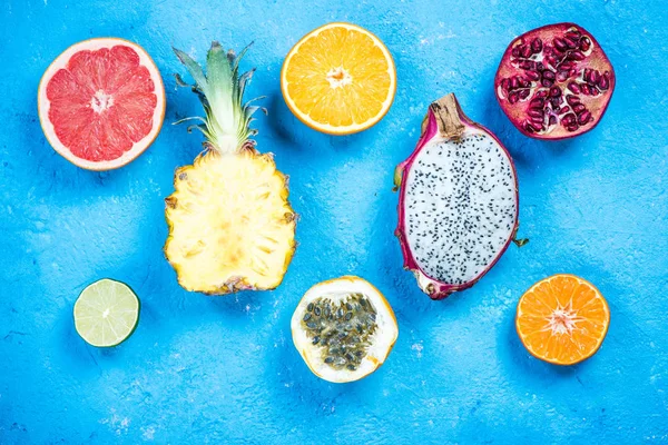 Mitades de frutas tropicales y exóticas en pizarra vibrante —  Fotos de Stock