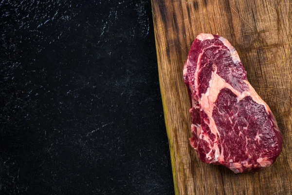 Rauwe biefstuk op houten bord, kopie ruimte — Stockfoto