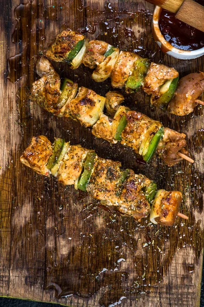 Grilled meat and vegetable skewers on wooden board — Stock Photo, Image