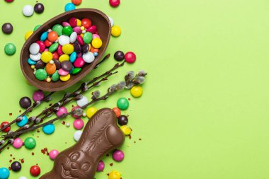 Paskalya arkaplanı. Şenlikli Çikolatalı Yumurta ve Tavşan. Renkli Ester Tatlı Yemekleri. Boşluğu Kopyala, Üst Görünüm.