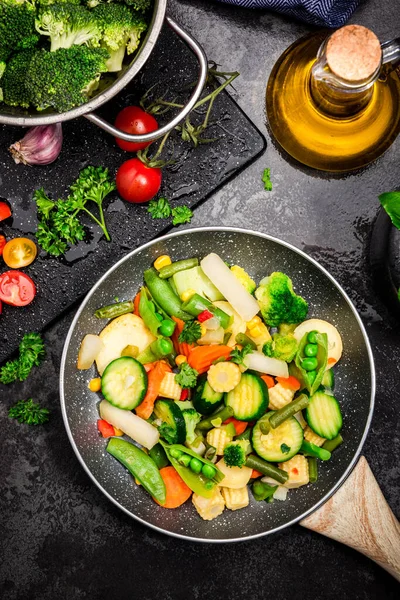 鍋に野菜を炒めます 健康的な食事と家庭での食事 ダークトーンの画像 トップダウン表示 — ストック写真