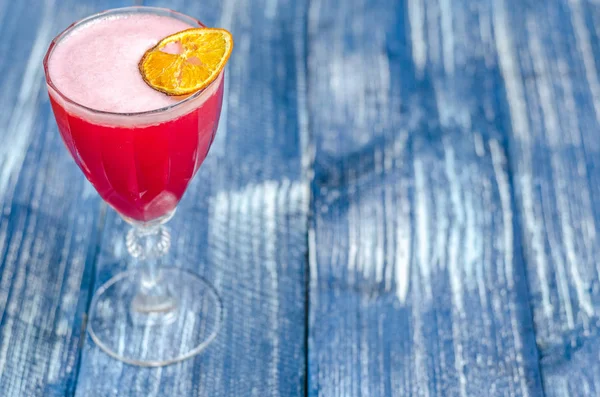 Ett glas rött cocktail med skum, citron — Stockfoto