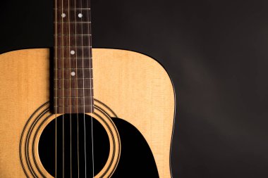 Siyah yalıtılmış zemin çerçevenin sol tarafında bir ahşap akustik gitar parçası