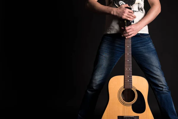 Chitarrista che tiene due mani con una chitarra acustica su uno sfondo nero isolato — Foto Stock