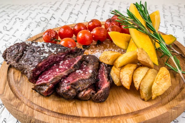 Mixed grilled meat, potatoes, tomatoes with herbs — Stock Photo, Image