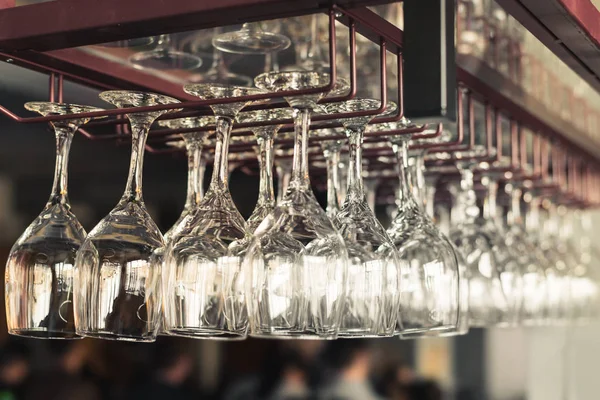 Una fila de copas de vino vacías limpias cuelgan — Foto de Stock