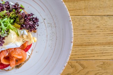 Kırmızı balık peynir ve ahşap bir masa üzerinde bir plaka üzerinde otlar ile sandviç görüntülemek yukarıdan