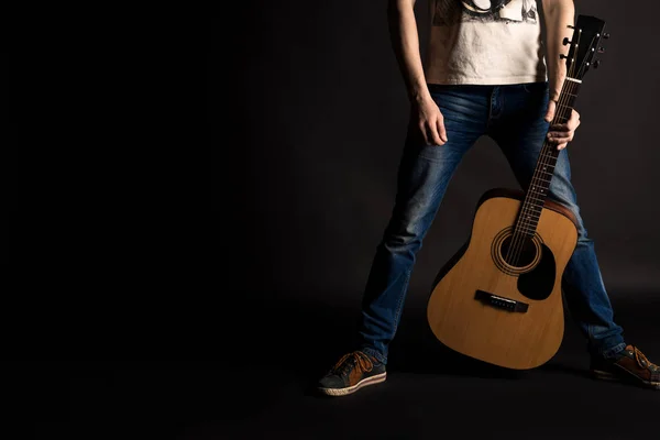 Chitarrista che tiene la mano sinistra con una chitarra acustica su uno sfondo nero isolato — Foto Stock