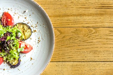 Bahar salatası: domates, kabak ve otlar, ahşap bir masa üzerinde beyaz bir plaka üzerinde