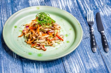 Et ve susam ve yeşil algler yeşil bir tabakta sebze salatası çatal bıçak takımı