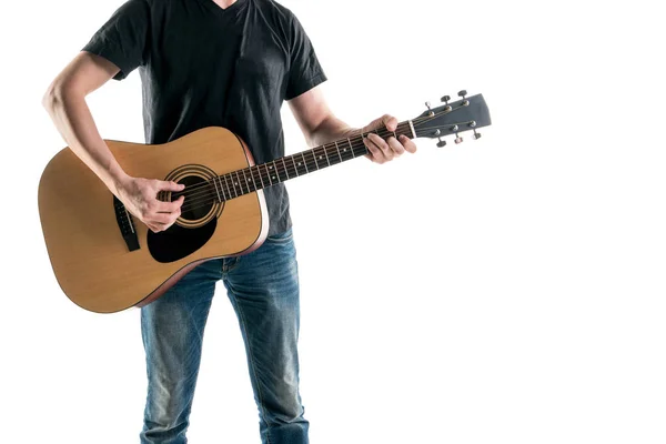 A guitarist in jeans and a black T-shirt, plays an acoustic guitar, on the left side of the frame, on a white background. Horizontal frame — Stock Photo, Image