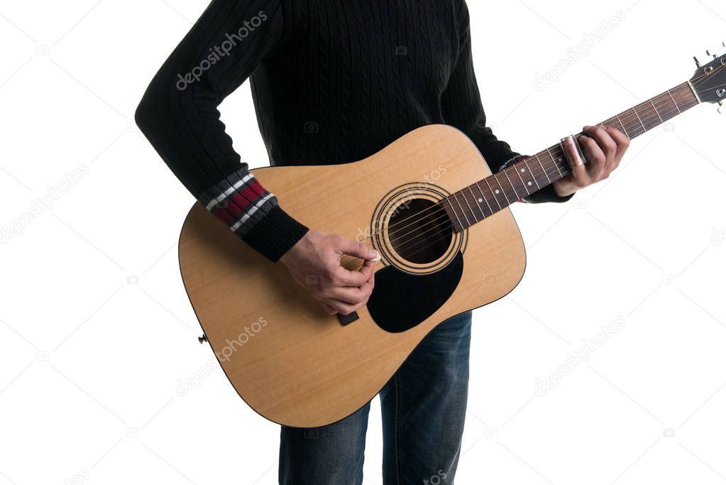 A guitarist in jeans and a black sweater, plays an acoustic guitar with a slider, in the center of the frame, on a white background. Horizontal frame.