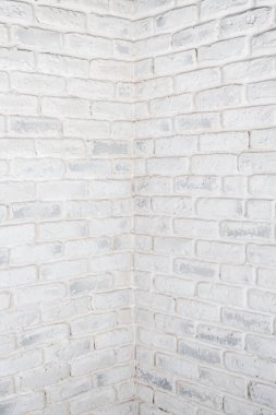 Dikey beyaz arka plan. Tuğla duvarın köşesinde.