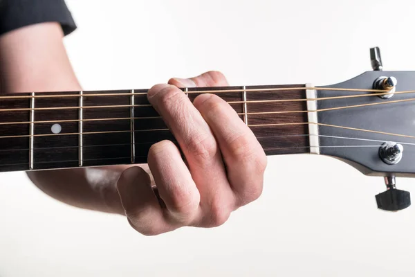 La mano del chitarrista blocca l'accordo G sulla chitarra, su uno sfondo bianco. Telaio orizzontale — Foto Stock