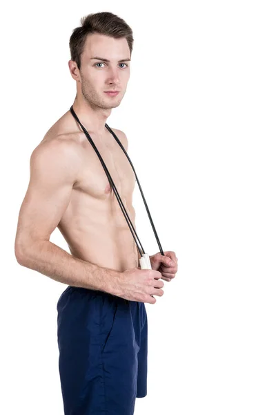 Healthy lifestyle and fitness. Handsome guy sports a physique, with a naked body, with a skipping rope in his hands, isolated on a white background. Vertical frame — Stock Photo, Image