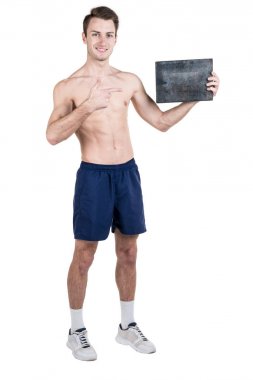 Sağlıklı bir yaşam tarzı. Beyaz bir arka plan üzerinde izole bir çıplak spor vücut ile yazmak için boş bir tabela olan yakışıklı bir adam portresi. Dikey Çerçeve