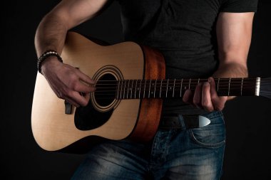 Gitar çalıyor. Akustik gitar gitarist elinde. Yatay Çerçeve