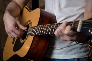 Gitar çalıyor. Akustik gitar gitarist elinde. Yatay Çerçeve