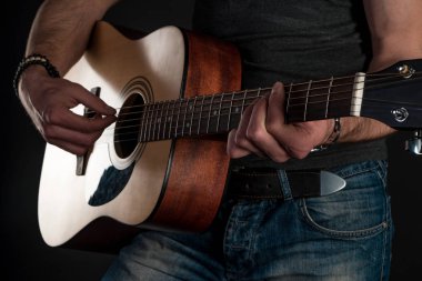 Gitar çalıyor. Akustik gitar gitarist elinde. Yatay Çerçeve