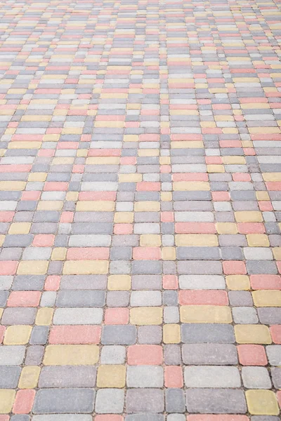 Тло, текстура міських різнокольорових тротуарів на всій рамі. Вертикальна рамка — стокове фото