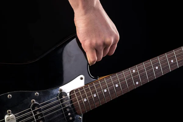 Musica e arte. Chitarra elettrica in mano, su uno sfondo nero isolato. Telaio orizzontale — Foto Stock