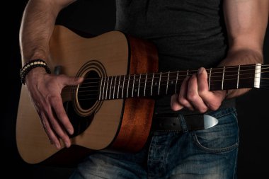 Gitar çalıyor. Akustik gitar gitarist elinde. Yatay Çerçeve