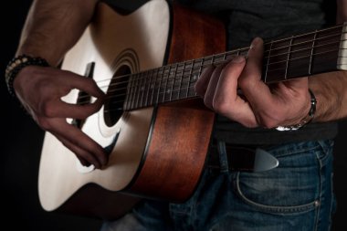 Gitar çalıyor. Akustik gitar gitarist elinde. Yatay Çerçeve