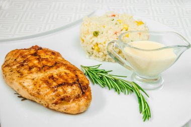 Lezzetli et pirzola, otlar, pirinç Mısır ve beyaz tabakta sos ile. Yatay Çerçeve