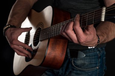 Gitar çalıyor. Akustik gitar gitarist elinde. Yatay Çerçeve