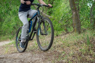 Seyahate orman yolu boyunca bir dağ bisikleti. Spor ve yaz aylarında aktif yaşam kavramı. Yatay Çerçeve